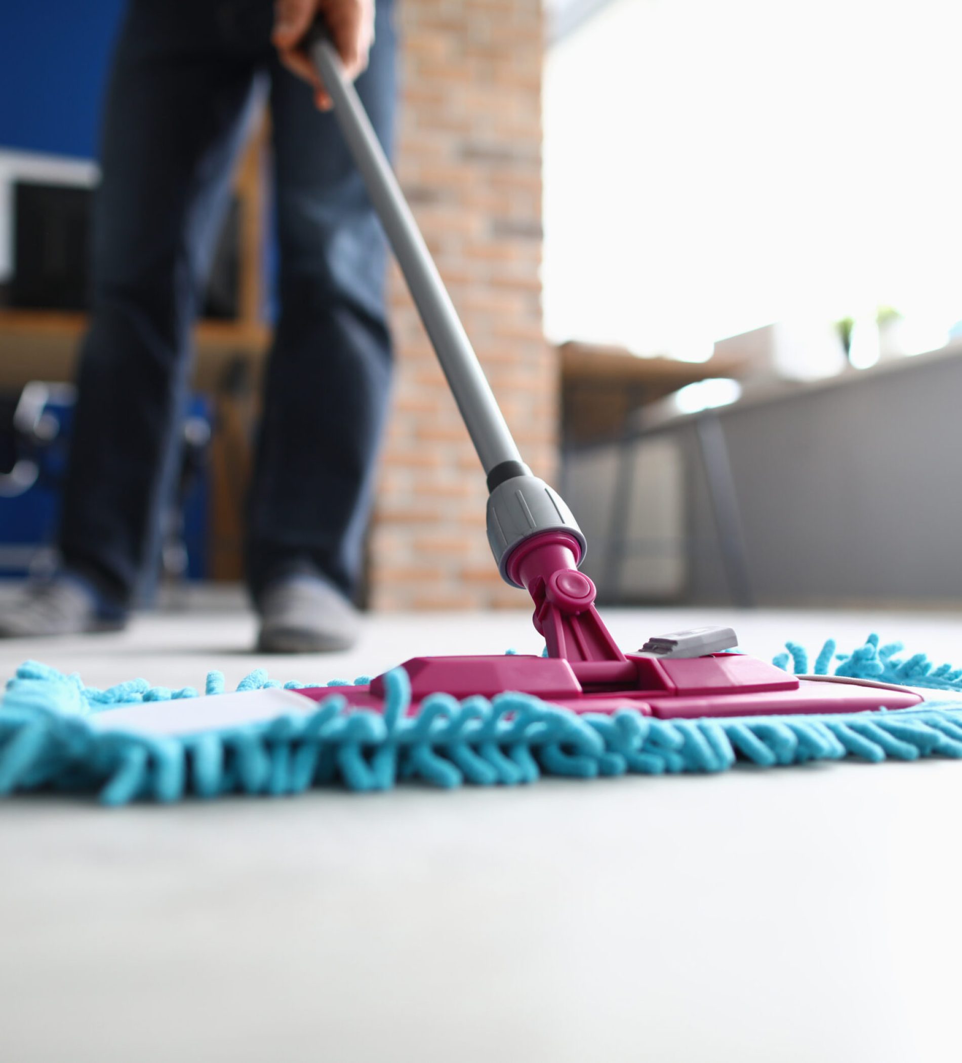 Man with mop washes floor in office. Cleaning company services concept